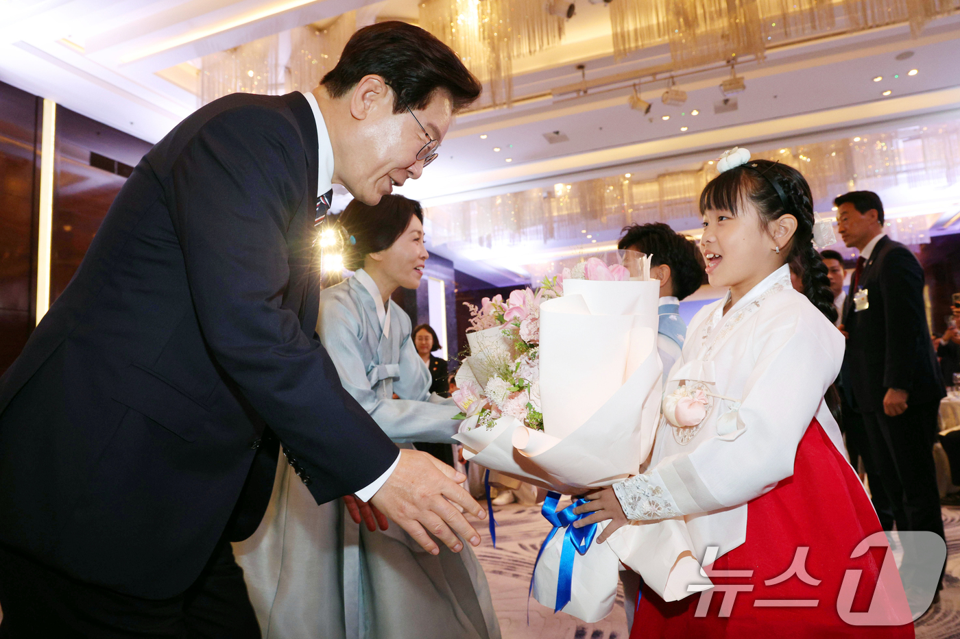 (하노이(베트남)=뉴스1) 이재명 기자 = 베트남을 국빈 방문 중인 이재명 대통령과 김혜경 여사가 22일(현지시간) 하노이의 한 호텔에서 열린 동포 오찬 간담회에서 화동에게 꽃다발 …