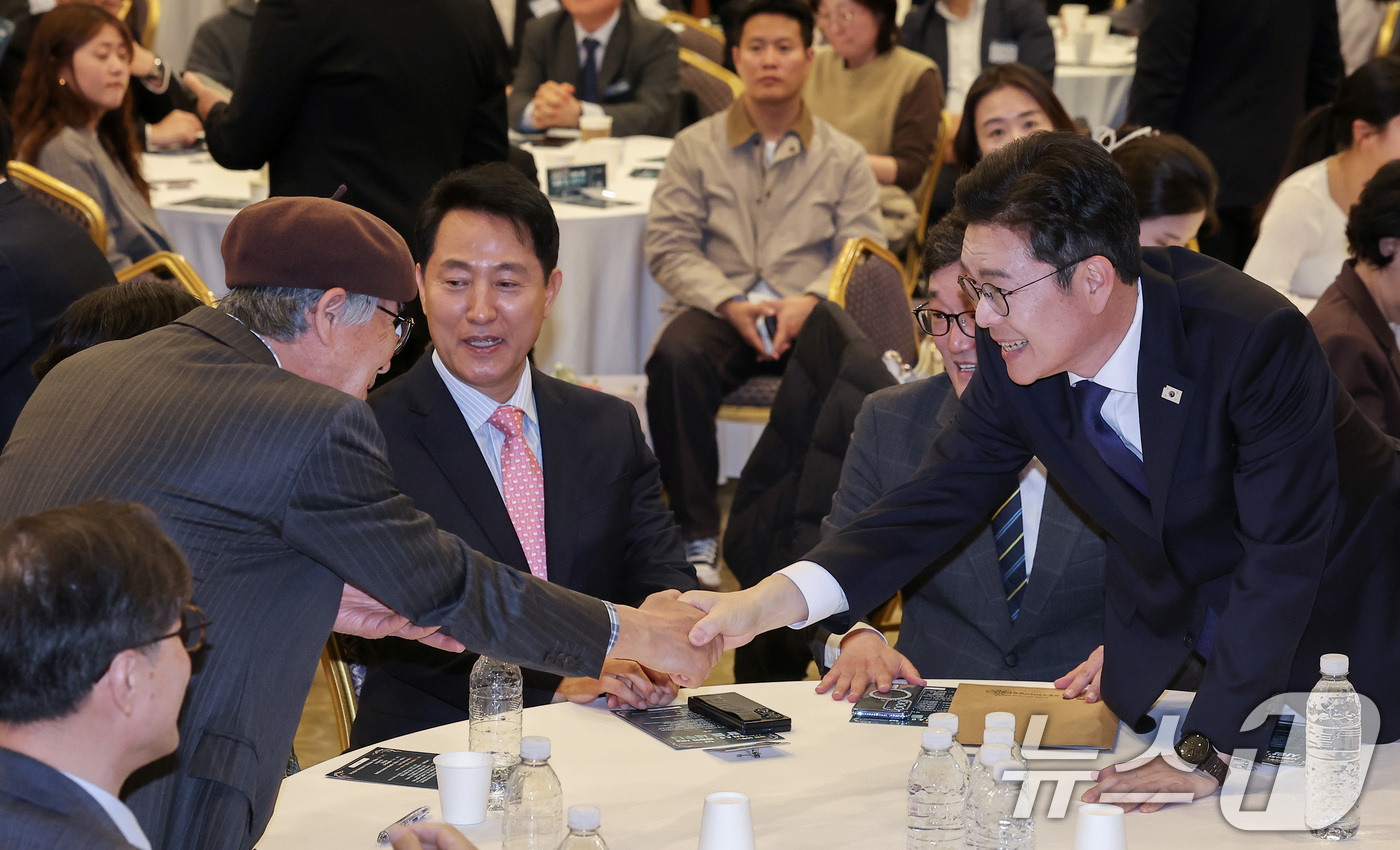 (서울=뉴스1) 김성진 기자 = 정원오 더불어민주당 서울시장 후보(오른쪽)가 22일 서울 용산구 백범김구기념관 컨벤션홀에서 열린 서울시사회복지사협회 40주년 기념식에서 참석자들과 …