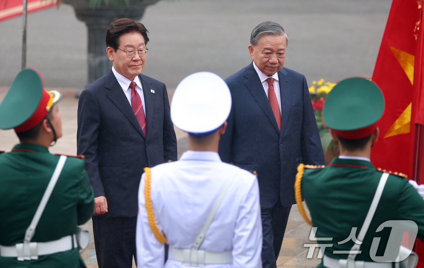 본문 이미지 - 이재명 대통령과 또 럼 베트남 당서기장이 22일(현지시간) 하노이 주석궁 대정원에서 열린 국빈 방문 공식환영식에서 의장대를 사열하고 있다. 2026.4.22 ⓒ 뉴스1 이재명 기자