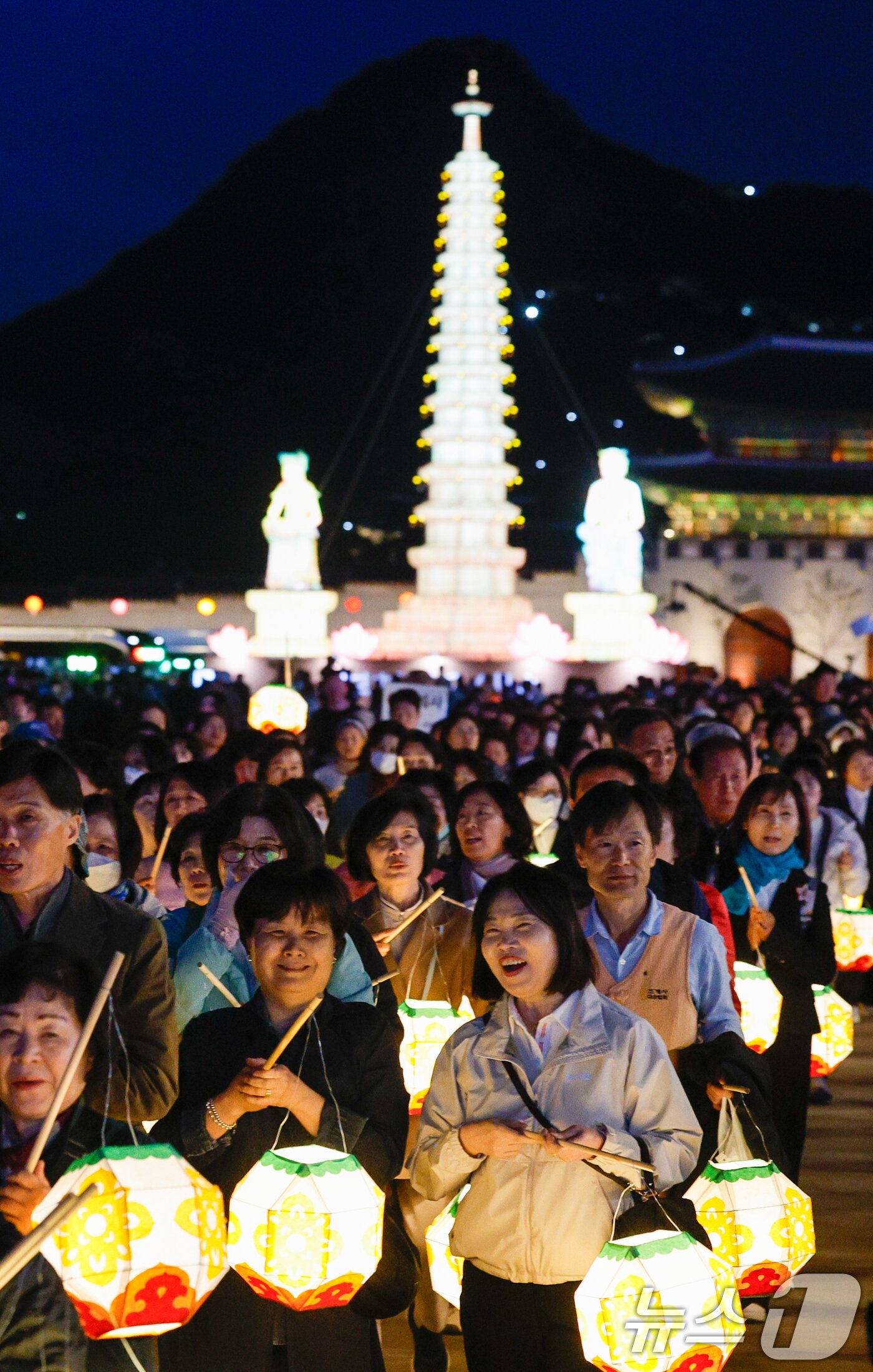 본문 이미지 - 부처님 오신 날을 앞두고 22일 오후 서울 종로구 광화문광장에서 열린 '평화와 화합의 보현사 탑등' 봉축점등식에서 불자들이 탑돌이를 하고 있다. 2026.4.22 ⓒ 뉴스1 안은나 기자