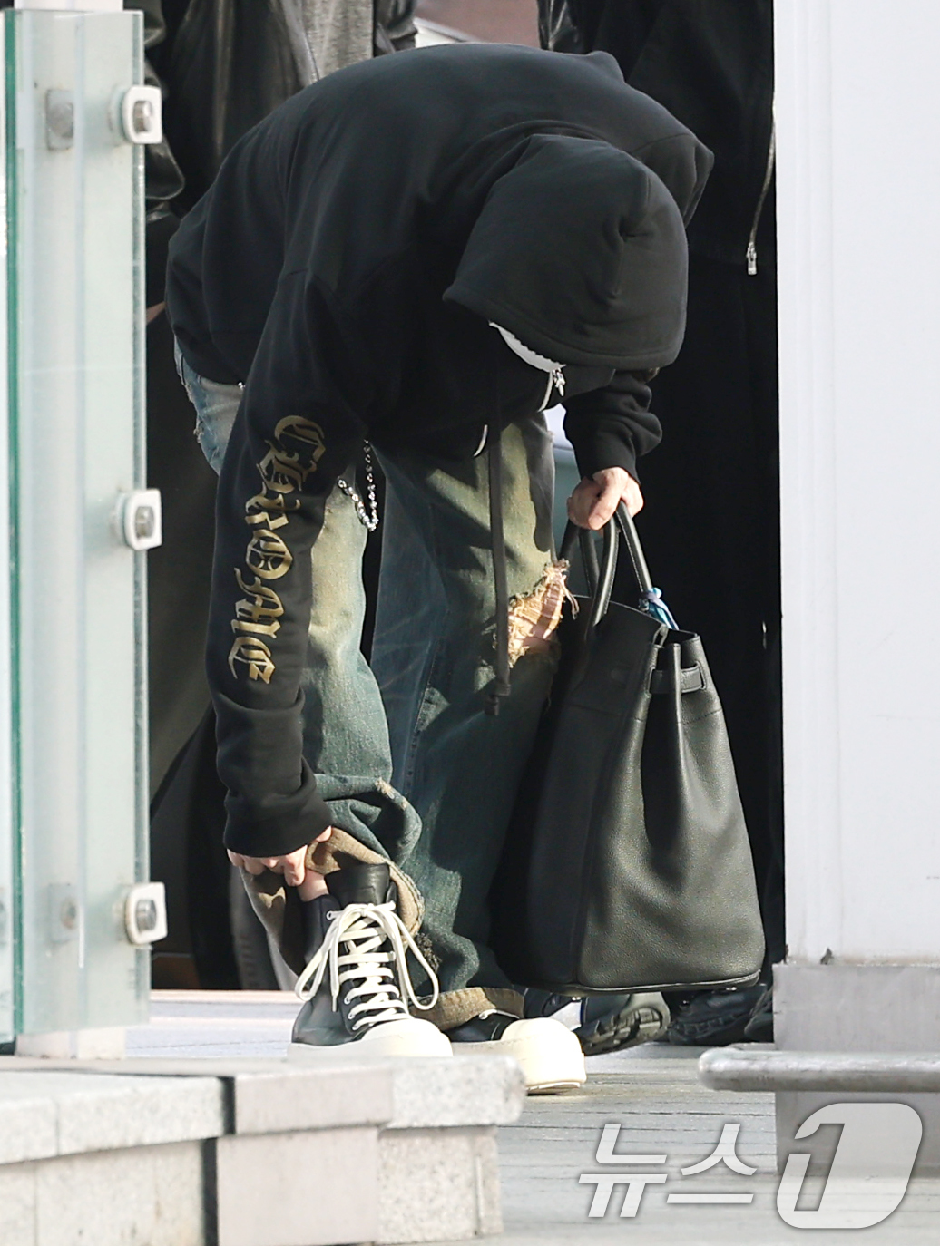 (인천공항=뉴스1) 권현진 기자 = 방탄소년단(BTS) 슈가가 22일 해외 일정을 위해 인천공항을 통해 미국 애틀란타로 출국하기 전 매무새를 고치고 있다. 2026.4.23/뉴스1 …