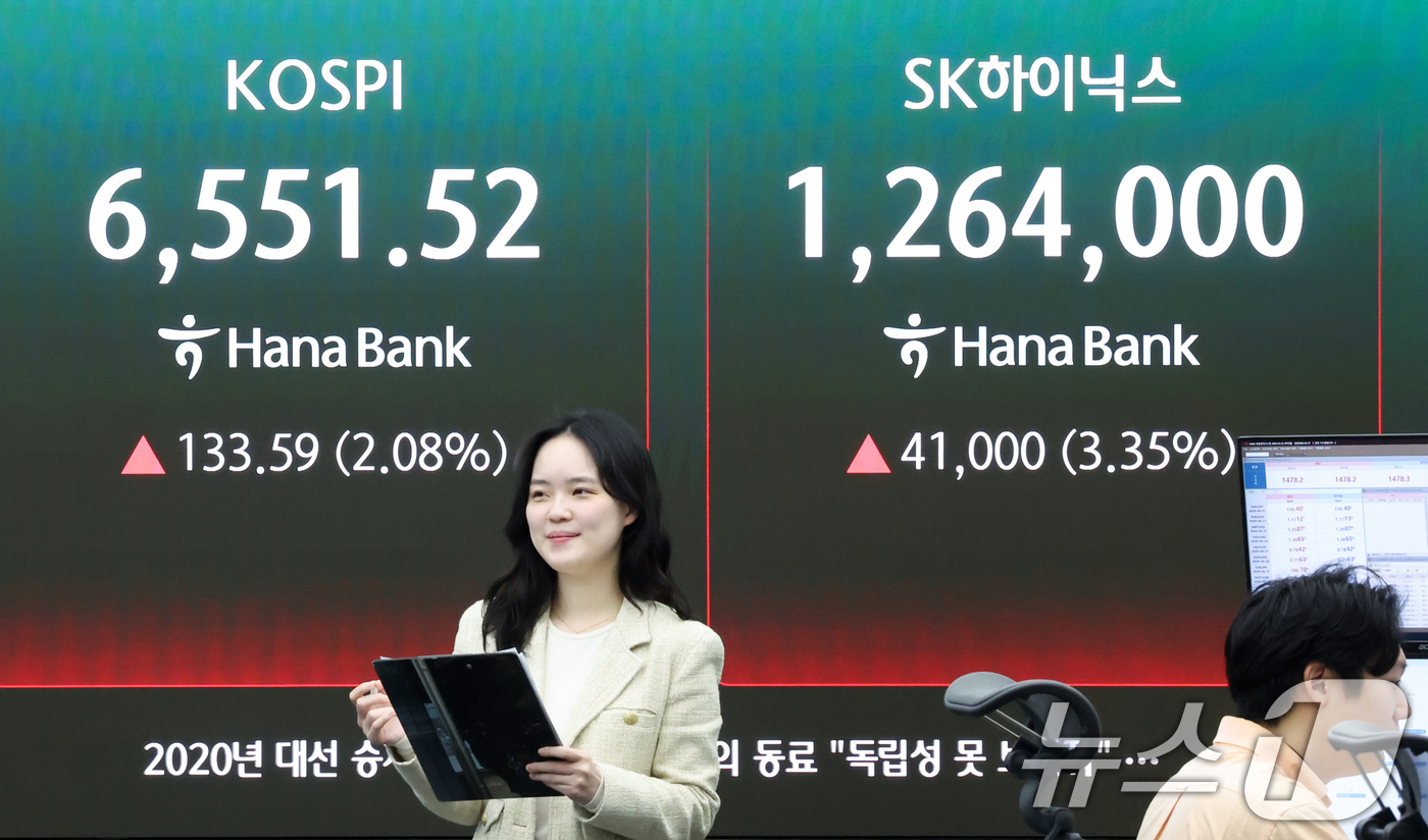 (서울=뉴스1) 임지훈 인턴기자 = 코스피가 장중 6550선을 넘은 23일 오전 서울 중구 하나은행 딜링룸 전광판에 코스피 지수와 SK하이닉스 주가가 표시되고 있다. 2026.4. …
