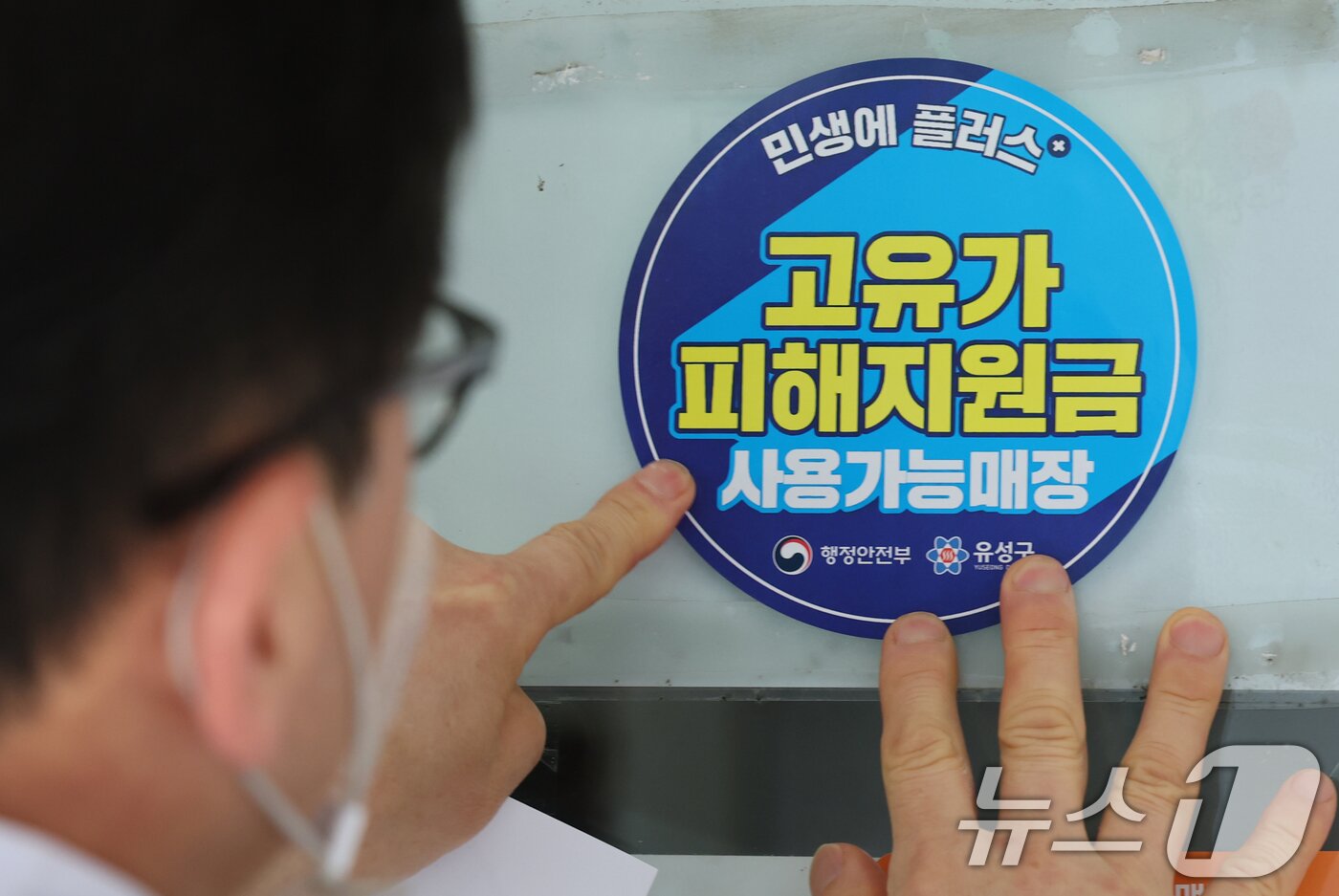 본문 이미지 - 고유가 피해지원금 신청을 앞두고 23일 대전 유성구 한 식당 주인이 피해지원금 사용가능매장 안내문을 붙이고 있다. 2026.4.23 ⓒ 뉴스1 김기태 기자