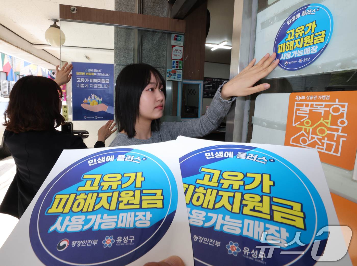 (대전=뉴스1) 김기태 기자 = 고유가 피해지원금 신청을 앞두고 23일 대전 유성구 한 식당에서 지역경제과 직원들이 피해지원금 안내문을 붙이고 있다.이번 지원금은 소득 하위 70% …