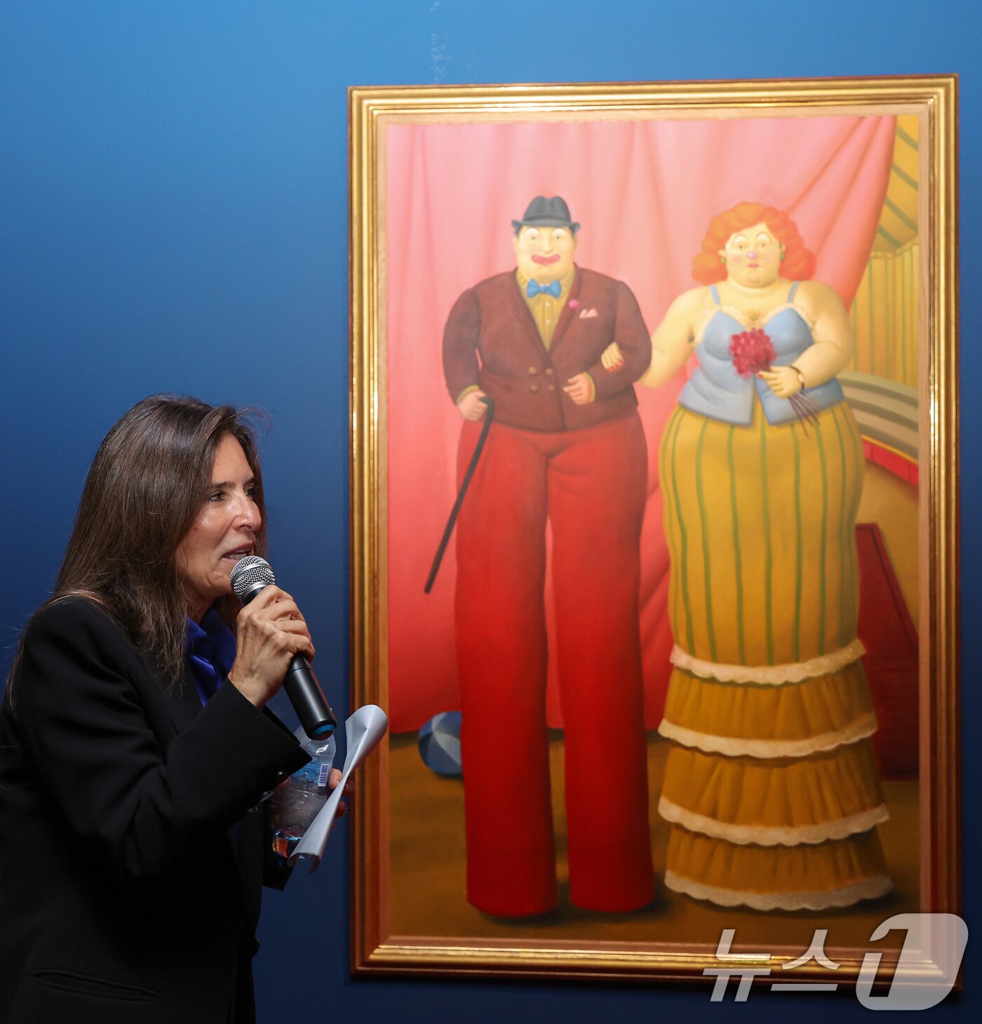 본문 이미지 - 페르난도 보테로의 딸이자 재단 대표인 리나 보테로가 23일 서울 서초구 예술의전당에서 '페르난도 보테로: 형태의 미학' 전시 프레스투어 중 '죽마를 탄 광대들' 작품 설명을 하고 있다.  ⓒ 뉴스1 안은나 기자