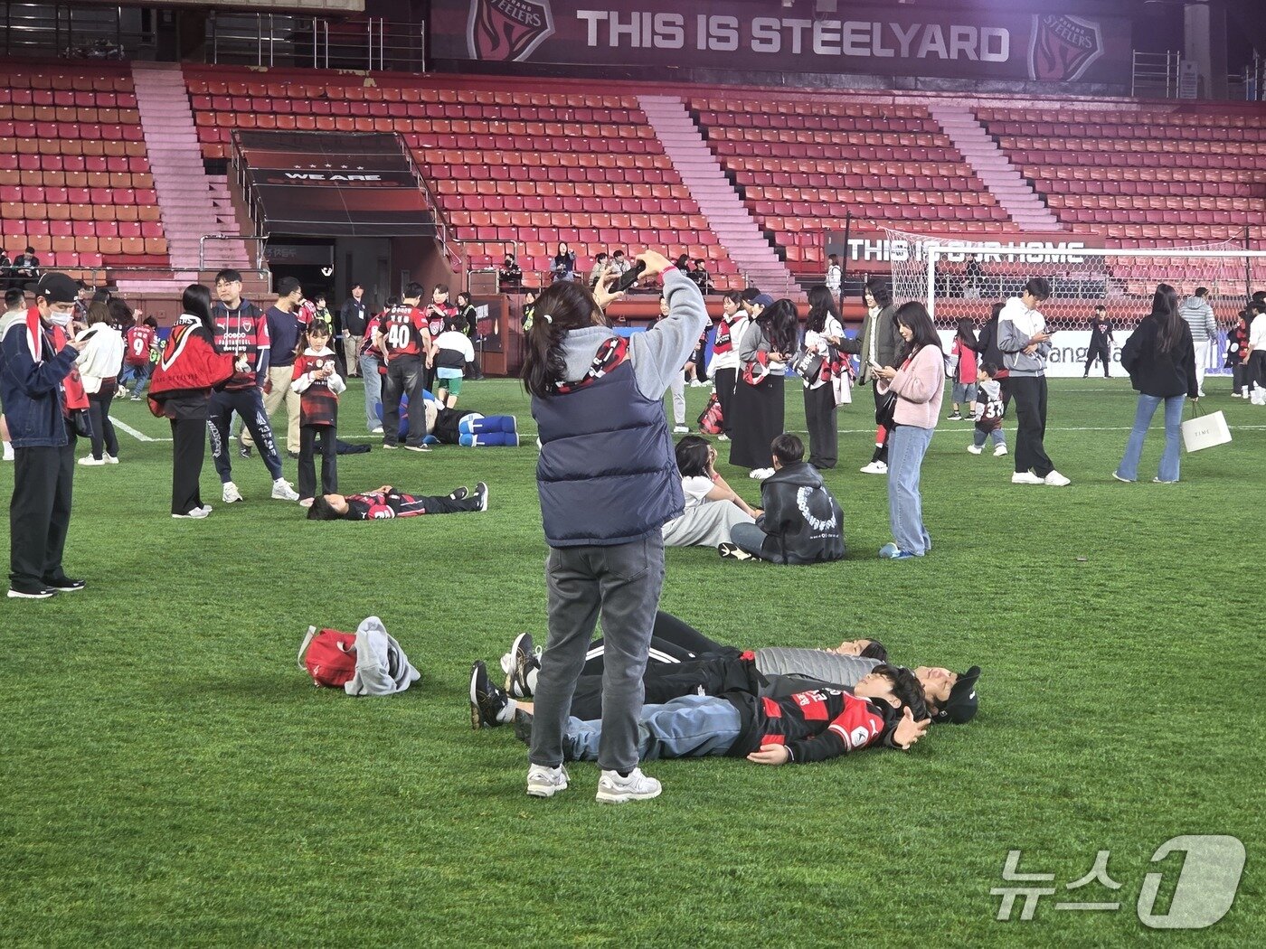 본문 이미지 - 잔디에 드러누워 인증샷을 찍는 포항 팬들ⓒ News1 안영준 기자 