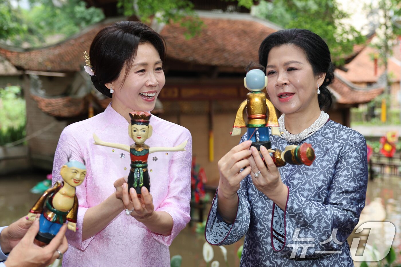 본문 이미지 - 이재명 대통령과 베트남을 국빈 방문중인 김혜경 여사가 23일(현지시간) 하노이 민족학 박물관에서 열린 배우자간 친교행사에서 또 럼 베트남 공산당 서기장의 부인 응오 프엉 리 여사가 선물한 인형을 들고 있다. 김 여사가 입고 있는 옷은 응오 프엉 리 여사가 선물한 베트남 전통복장 아오자이다. 2026.4.23 ⓒ 뉴스1 이재명 기자