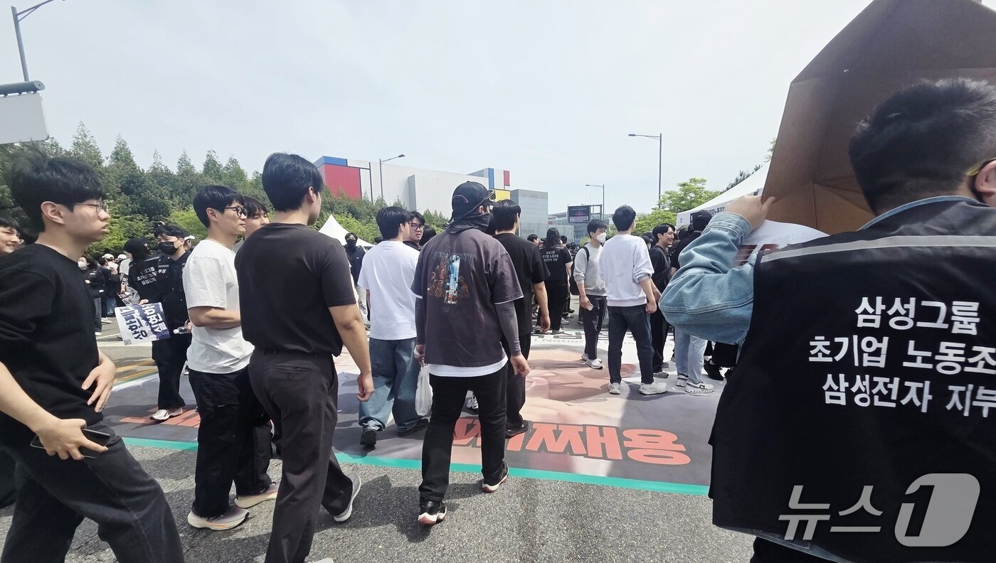 본문 이미지 -  23일 경기 평택시 고덕동 삼성전자 평택캠퍼스에서 열린 삼성전자 노동조합 공동투쟁본부 '4·23 투쟁 결의대회'에서 이재용 삼성전자 회장, 전영현 삼성전자 대표이사 부회장, 노태문 삼성전자 사장의 사진을 밟고 지나가고 있다. 2026.4.23 ⓒ 뉴스1 박기범 기자  