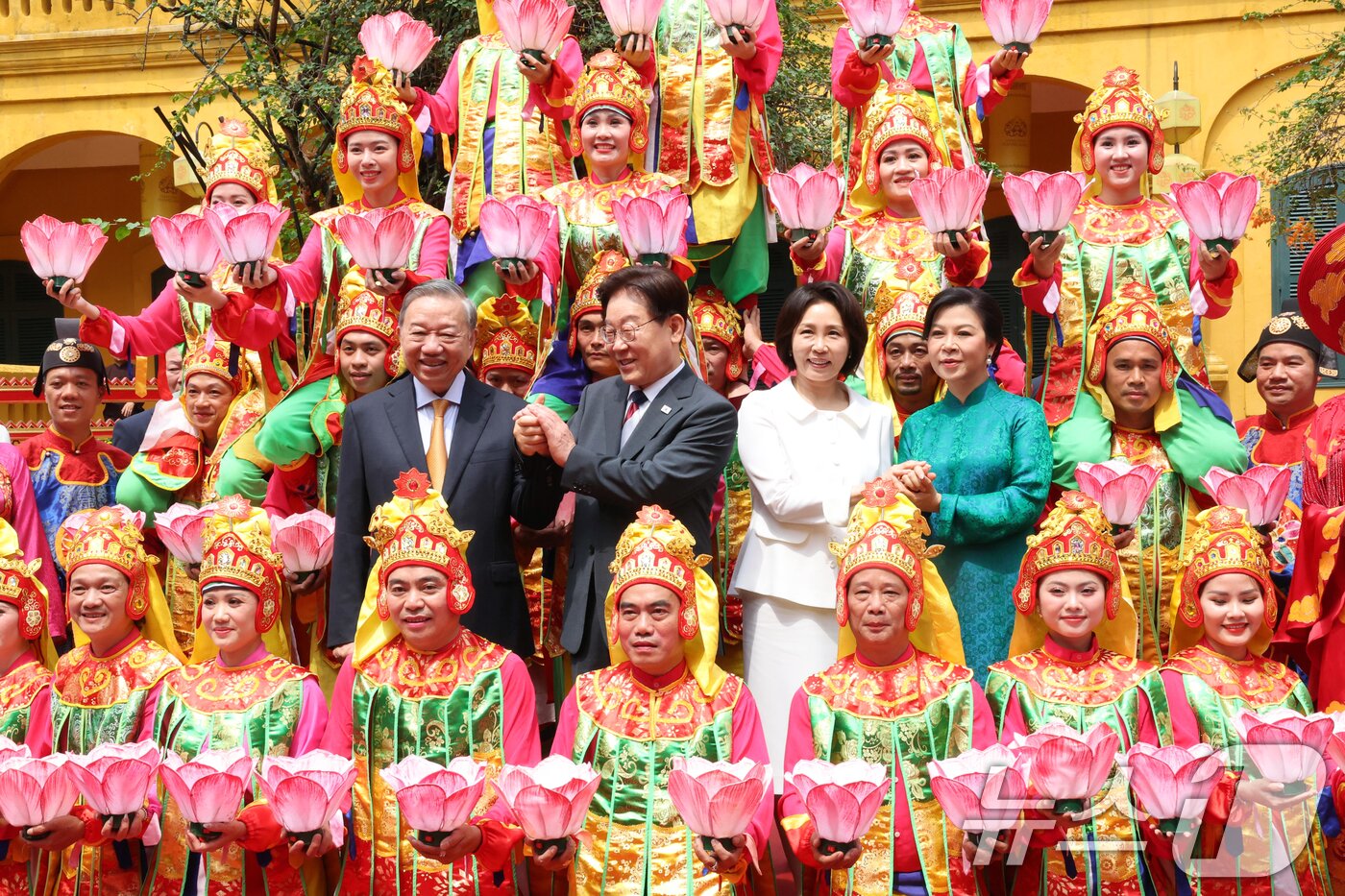 본문 이미지 - 이재명 대통령, 김혜경 여사와 또 럼 베트남 당 서기장 겸 국가주석, 응오 프엉 리 여사가 24일(현지시간) 친교일정으로 베트남 탕롱 황성를 방문해 공연단과 기념촬영을 하고 있다. 2026.4.24 ⓒ 뉴스1 이재명 기자
