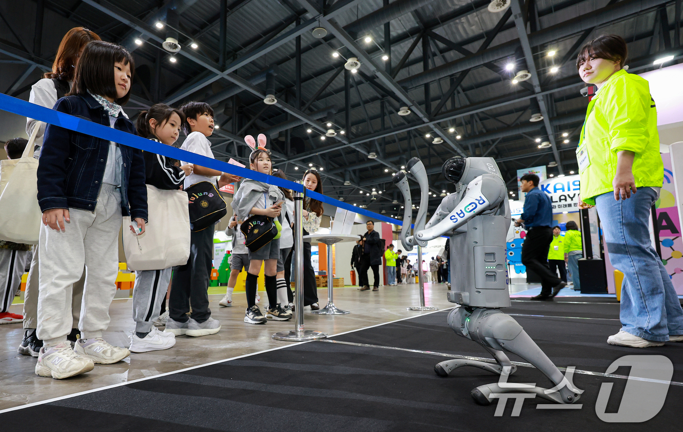 (고양=뉴스1) 이호윤 기자 = 24일 경기도 고양시 일산서구 킨텍스 제1전시장에서 열린 ‘2026 대한민국 과학축제 IN 경기’를 찾은 학생들이 로봇 강아지를 살펴보고 있다.이번 …