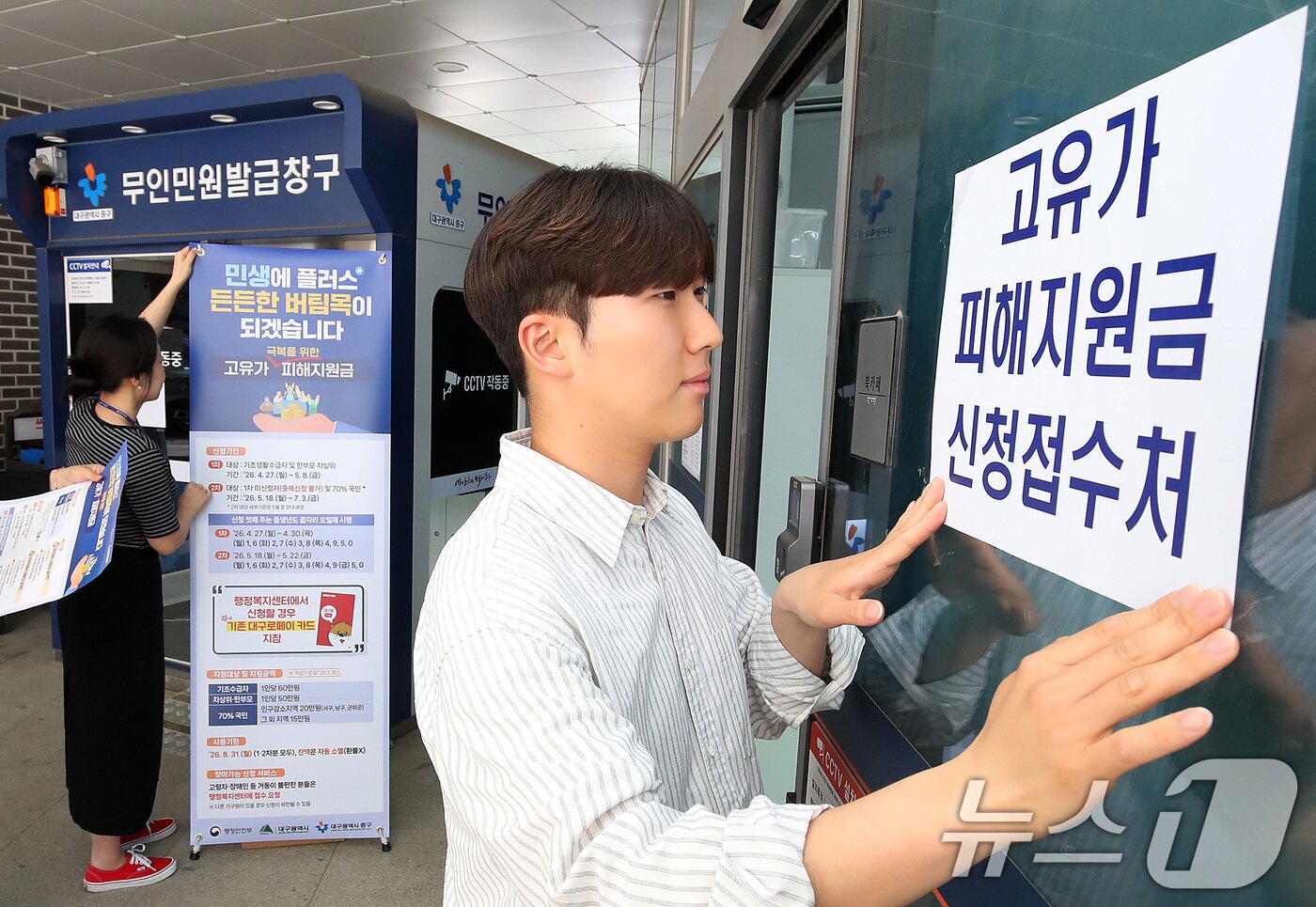본문 이미지 - 다음 주 월요일(27일) 시작되는 '고유가 피해지원금' 신청 접수를 앞두고 24일 대구 중구 성내3동 행정복지센터에서 직원들이 안내문을 붙이고 있다. 2026.4.24 ⓒ 뉴스1 공정식 기자