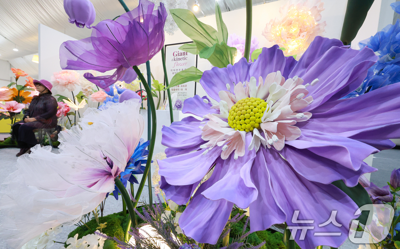 (고양=뉴스1) 이호윤 기자 = 24일 경기도 고양시 일산호수공원에서 열린 '제18회 고양국제꽃박람회'를 찾은 관람객이 실내 꽃 전시를 둘러보고 있다.이번 박람회는 '꽃, 시간을 …