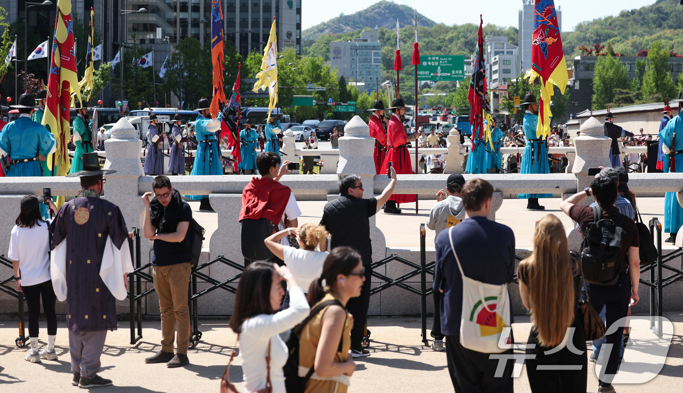 (서울=뉴스1) 임지훈 인턴기자 = 서울 낮 최고 기온이 26도까지 올라가는 등 초여름 날씨를 보인 24일 서울 종로구 경복궁을 찾은 외국인 관광객들이 수문장 교대식을 관람하고 있 …