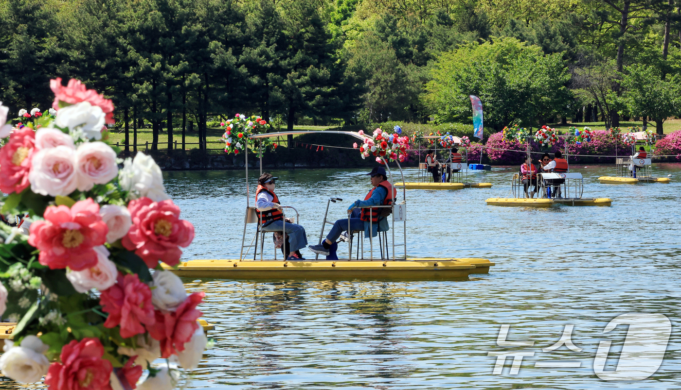 (고양=뉴스1) 이호윤 기자 = 24일 경기도 고양시 일산호수공원에서 열린 '제18회 고양국제꽃박람회'를 찾은 관람객들이 수상꽃자전거를 타고 있다.이번 박람회는 '꽃, 시간을 물들 …