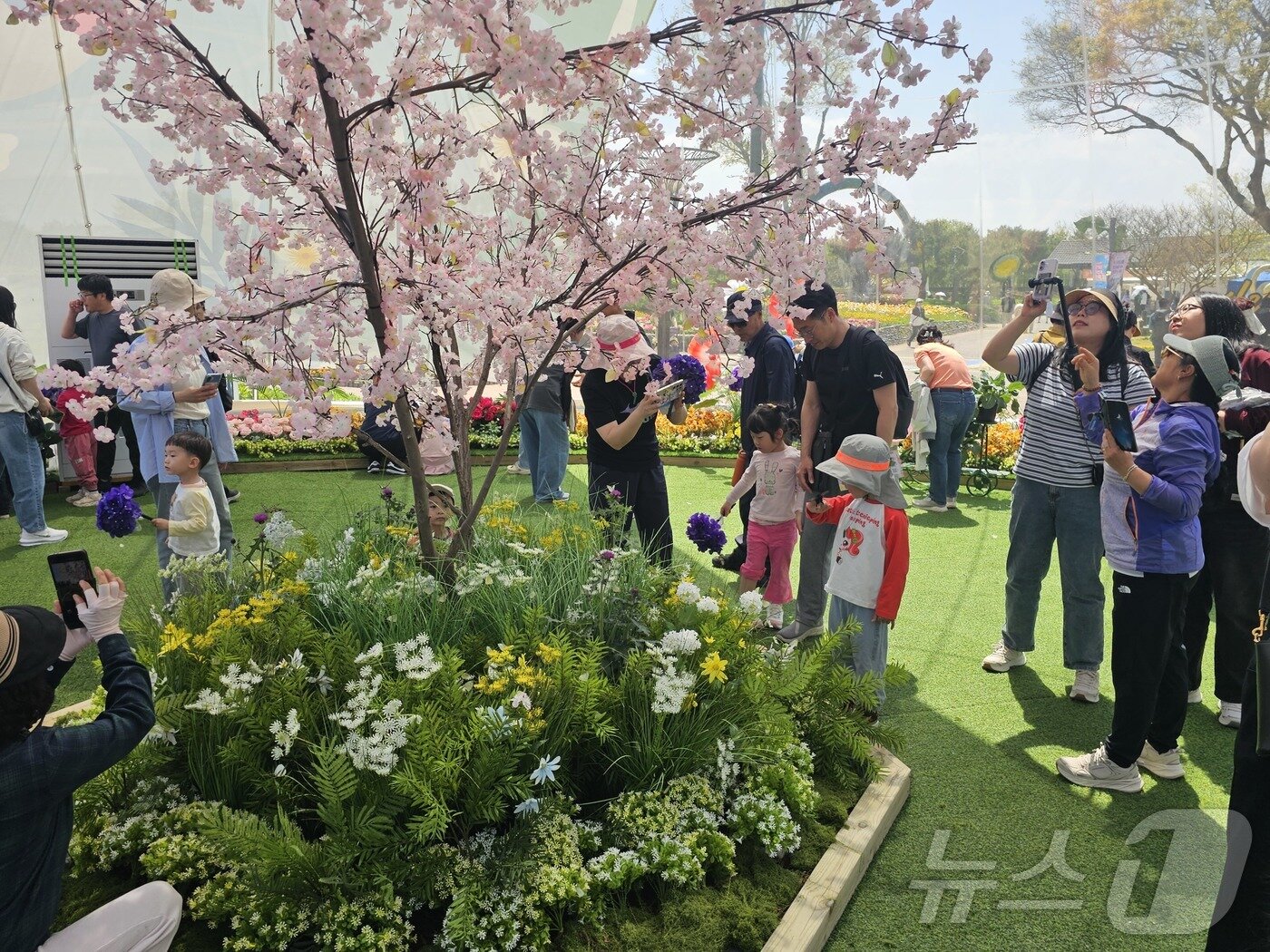본문 이미지 - 26일 오전 전남 함평 나비대축제를 찾은 아이들이 나비 먹이 주기 체험을 하고 있다. 2026.4.26 ⓒ 뉴스1 최성국 기자