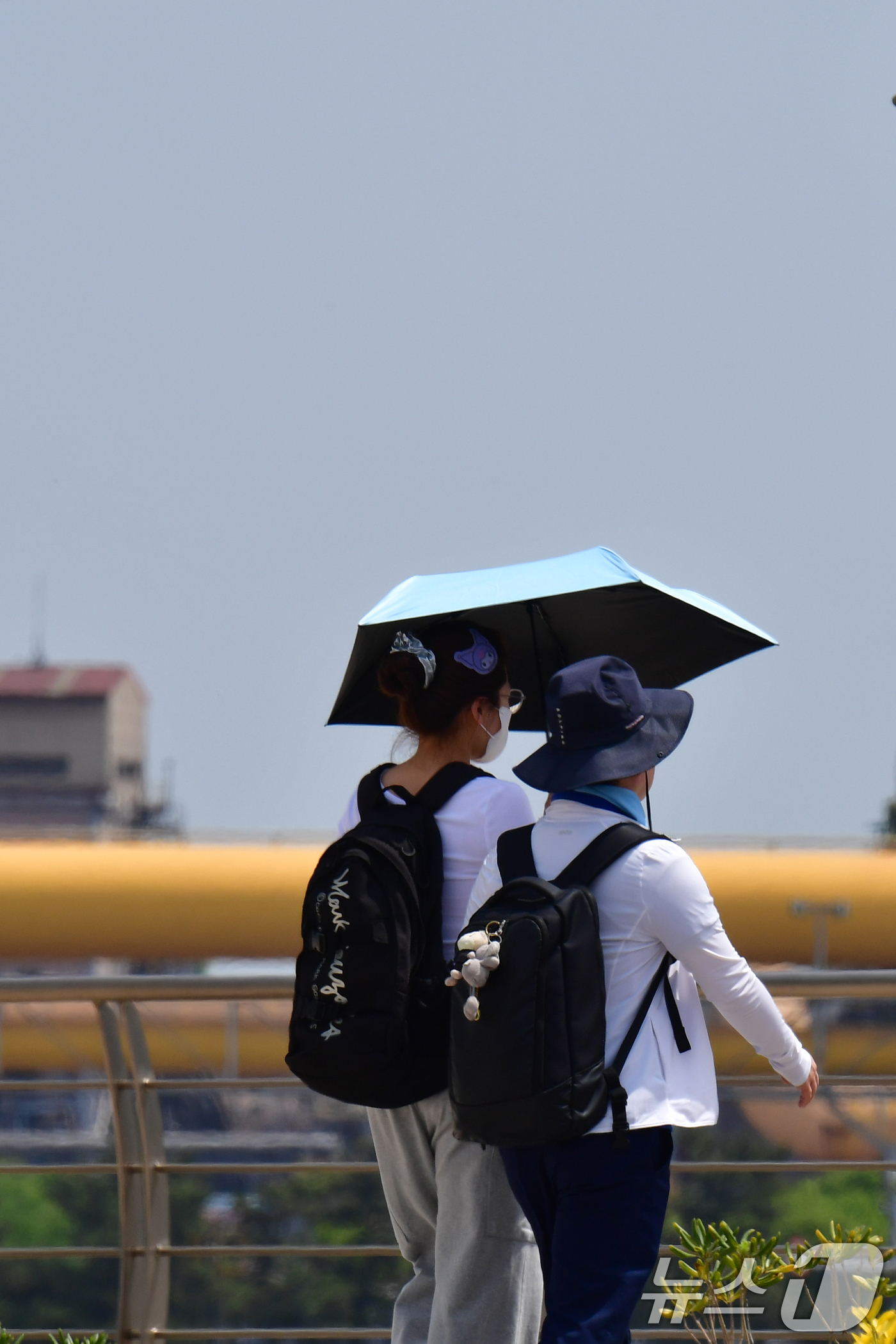 (포항=뉴스1) 최창호 기자 = 26일 경북 포항시 송도해수욕장 해안길에서 양산을 쓴 관광객들이 걸어가고 있다.  2026.4.26/뉴스1