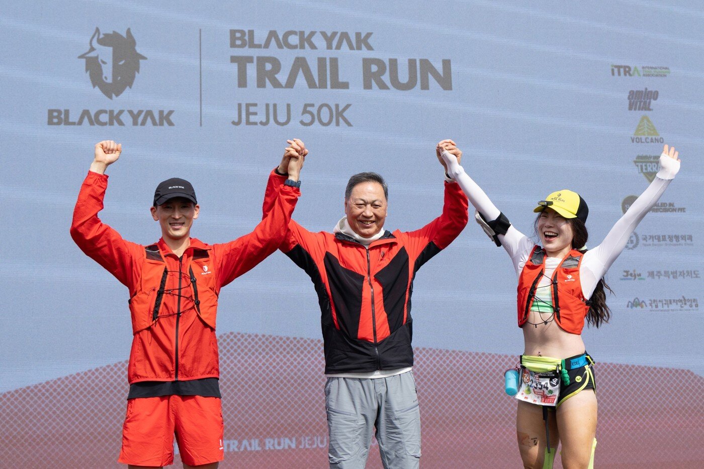 본문 이미지 - 강태선 회장(가운데)이 25일 '블랙야크 트레일 런 제주 50K'에서 우승한 이규호·민소연 선수와 함께 시상식에서 손을 들어올리고 있다.(BYN블랙야크그룹 제공)