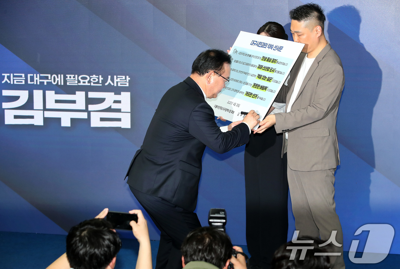 (대구=뉴스1) 공정식 기자 = 김부겸 더불어민주당 대구시장 예비후보가 26일 오후 대구 달서구 선거사무소 개소식에서 대구시민과의 약속 선서문에 서명하고 있다. 2026.4.26/ …