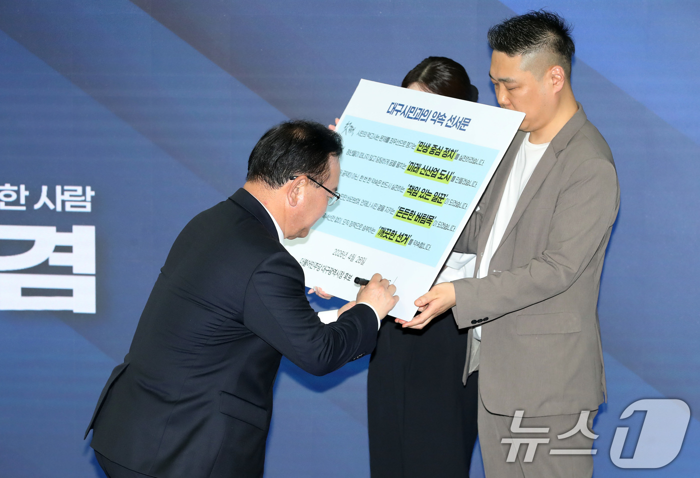 (대구=뉴스1) 공정식 기자 = 김부겸 더불어민주당 대구시장 예비후보가 26일 오후 대구 달서구 선거사무소 개소식에서 대구시민과의 약속 선서문에 서명하고 있다. 2026.4.26/ …