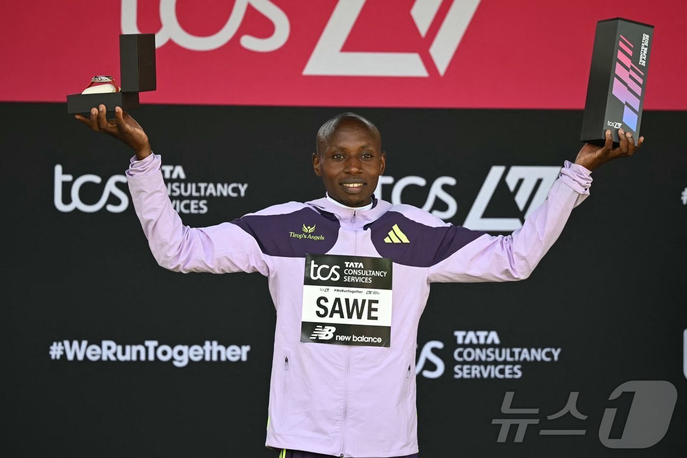 본문 이미지 - 세계 신기록을 기록한 케냐의 사바스티안 사웨가 26일 영국 런던에서 열린 2026 런던 마라톤 남자부 경기 시상식에서 트로피를 들고 있다. ⓒ AFP=뉴스1