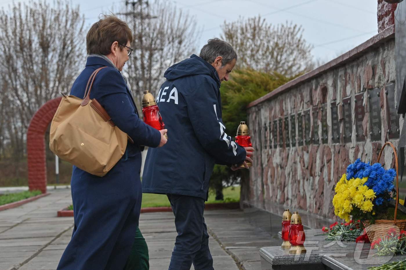 본문 이미지 - 라파엘 그로시 국제원자력기구(IAEA) 사무총장(오른쪽)이 26일(현지시간) 체르노빌 원자력 발전소의 추모비에 참배하고 있다. 2026.04.26. ⓒ AFP=뉴스1
