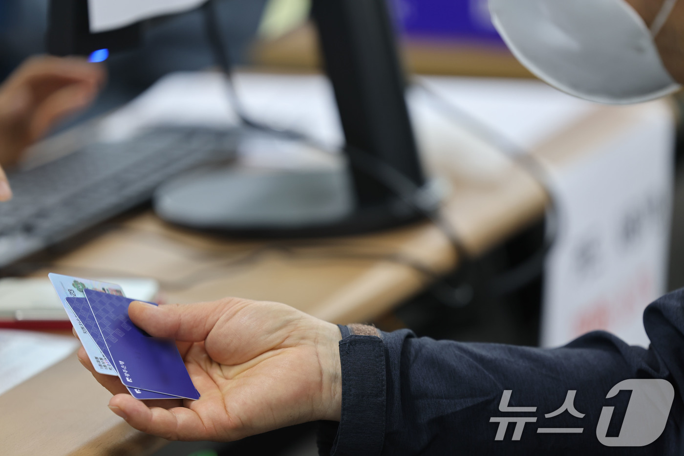 (광주=뉴스1) 박지현 기자 = 최대 60만원 상당의 고유가 피해지원금 1차 지급이 시작된 27일 오전 광주 북구 두암3동 행정복지센터에서 한 시민이 신청을 마치고 카드를 받고 있 …