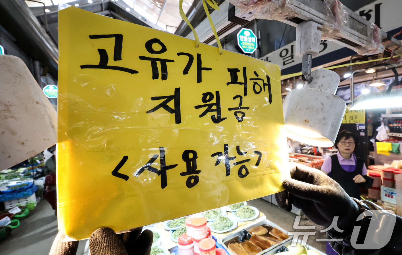 (서울=뉴스1) 임지훈 인턴기자 = 고유가 피해지원금 1차 지급 신청일인 27일 서울 동대문구 경동시장 한 점포에서 직원이 ’고유가 피해지원금 사용 가능‘ 안내문을 게시하고 있다. …