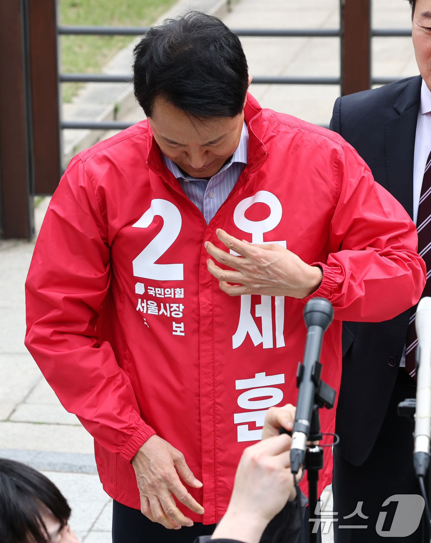 (서울=뉴스1) 최지환 기자 = 6.3 지방선거 서울시장 예비후보자 등록을 마친 오세훈 국민의힘 후보가 27일 서울 종로구 보신각 앞에서 기자회견을 앞두고 후보복을 착용하고 있다. …