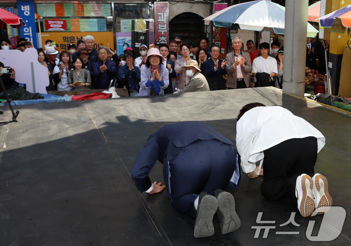 (부산=뉴스1) 윤일지 기자 = 전재수 더불어민주당 부산시장 후보가 27일 오후 부산 북구 구포시장에서 열린 '북구 주민 감사 인사' 행사에서 큰절을 하고 있다. 2026.4.27 …
