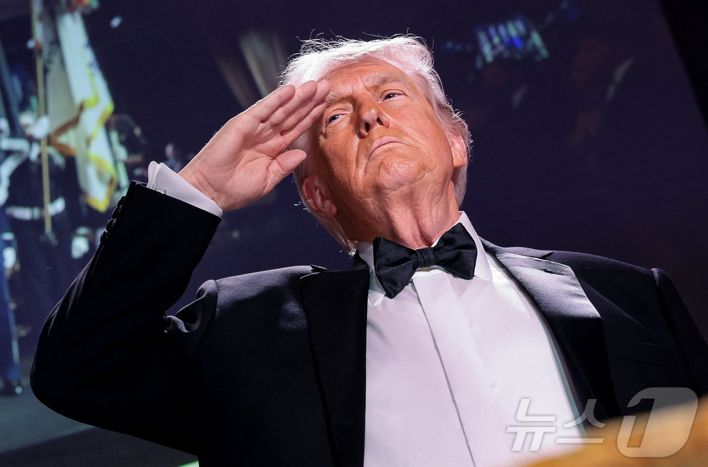 (로이터=뉴스1) = 도널드 트럼프 미국 대통령이 지난 25일(현지시각) 미국 워싱턴 D.C.에서 열린 백악관 출입기자단 연례 만찬에서 거수경례를 하고 있다. 2026. 04. 2 …