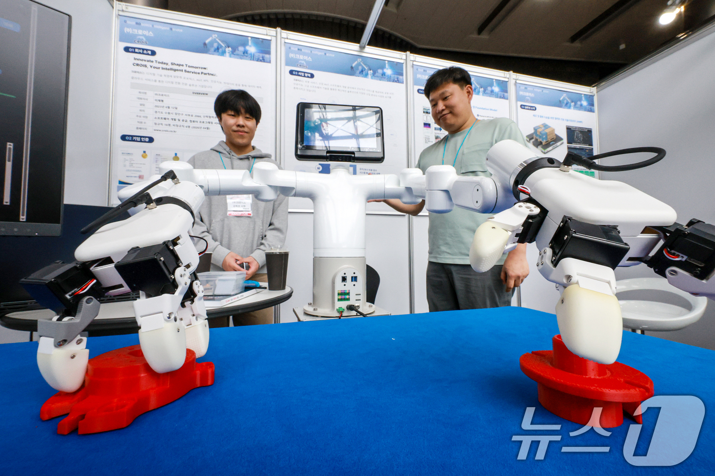 (서울=뉴스1) 이호윤 기자 = 27일 서울 강남구 코엑스 그랜드볼룸에서 열린 '2026 자율제조AI 월드쇼'에서 관계자들이 산업로봇을 소개하고 있다.  2026.4.27/뉴스1