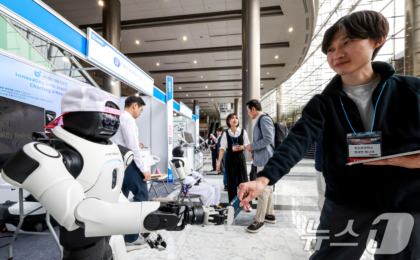 (서울=뉴스1) 이호윤 기자 = 27일 서울 강남구 코엑스 그랜드볼룸에서 열린 '2026 자율제조AI 월드쇼'에서 관계자들이 산업로봇을 소개하고 있다. 2026.4.27/뉴스1