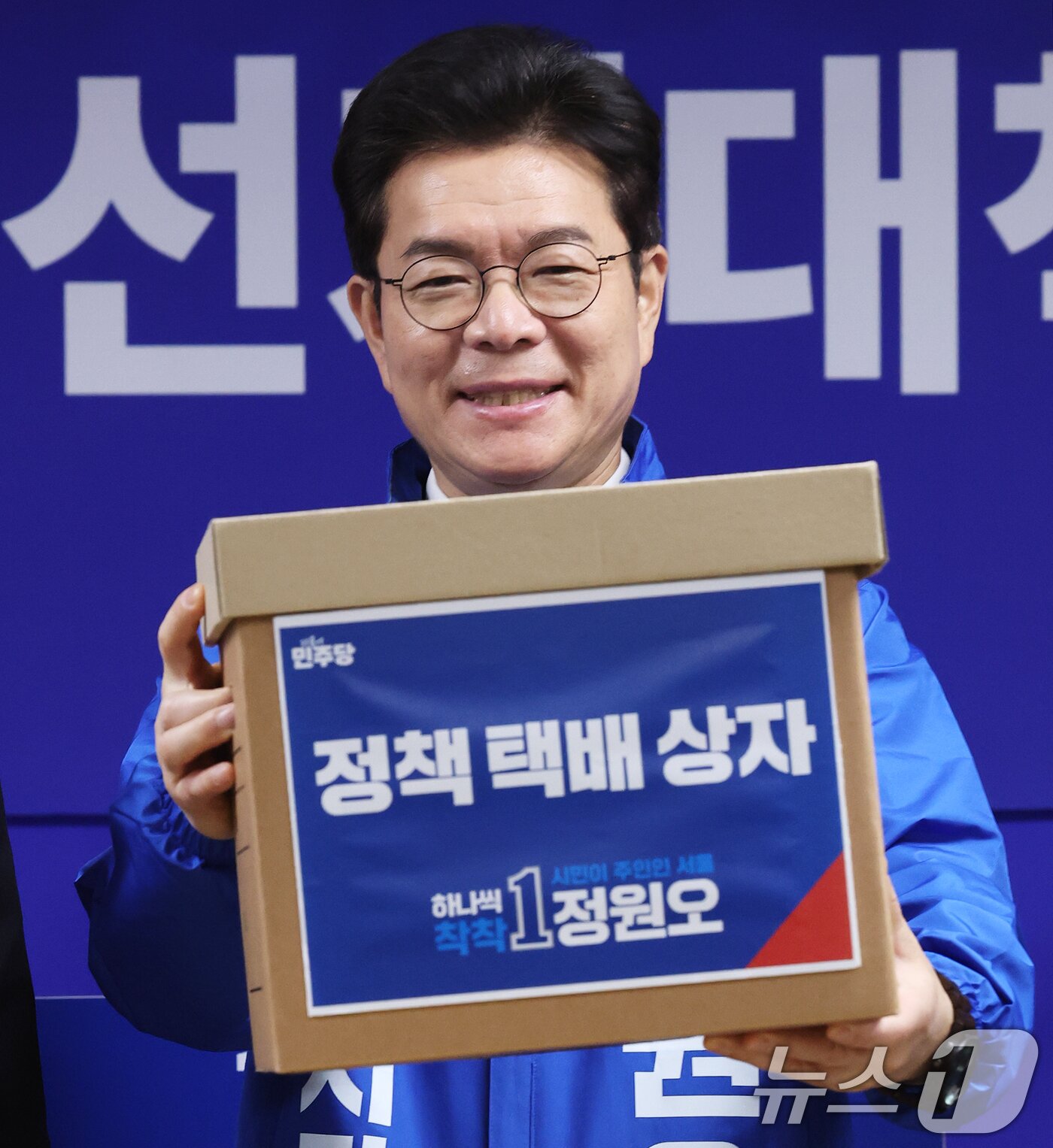 본문 이미지 - 정원오 더불어민주당 서울시장 후보가 28일 서울 중구 선거대책위원회 사무실에서 열린 공개 선거대책위원회 회의에서 김형남 상임선대위원장으로부터 서울 25개 자치구 정책 공약이 담긴 택배상자를 전달받고 있다. 2026.4.28 ⓒ 뉴스1 오대일 기자