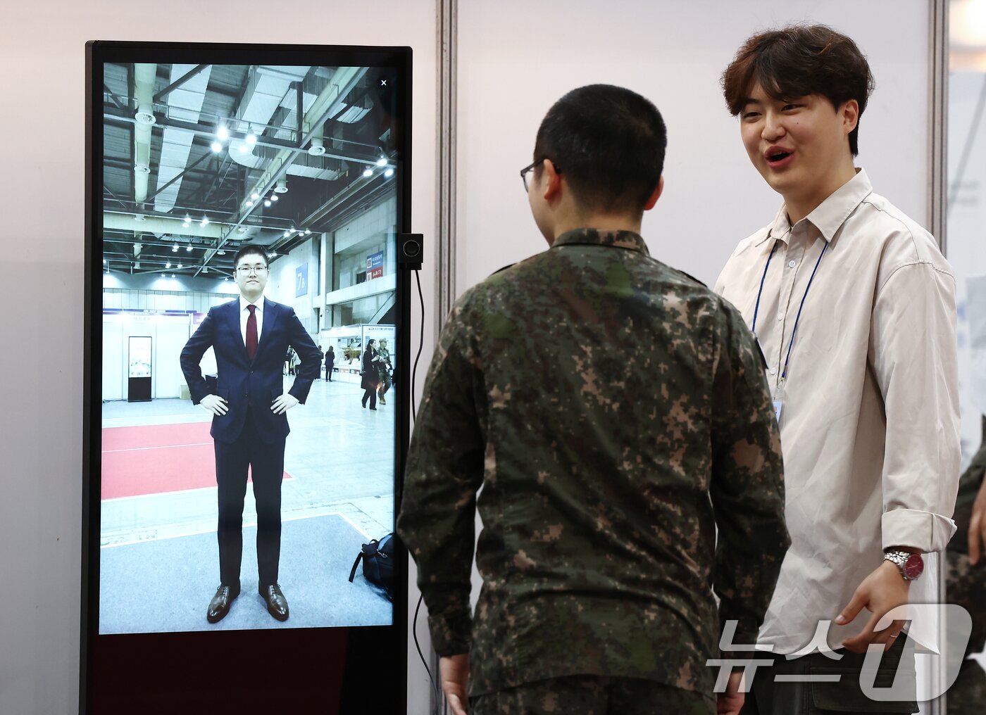 본문 이미지 - 28일 경기 고양 킨텍스에서 열린 2026년 국군장병 취업박람회에서 장병이 AI 면접 복장 체험을 하고 있다. 2026.4.28 ⓒ 뉴스1 김민지 기자