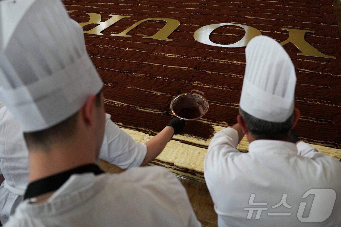 본문 이미지 - 26일(현지시간) 영국 런던 첼시 타운홀에서 셰프들과 자원봉사자들이 세계 최장 티라미수 기네스 기록을 경신하는 모습.2026.04.26. ⓒ 로이터=뉴스1