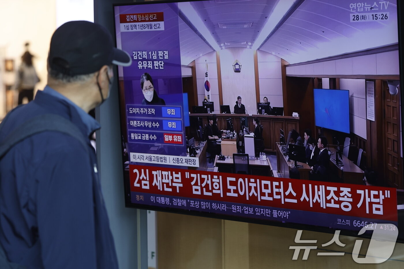 본문 이미지 - 28일 오후 서울시 용산구 한강대로 서울역 대합실에서 시민들이 자본시장과 금융투자업에 관한 법률 위반, 정치자금법 위반, 특정범죄 가중처벌 등에 관한 법률 위반(알선수재) 혐의를 받는 김건희 여사의 항소심 선고공판 생중계를 지켜보고 있다. 2026.4.28 ⓒ 뉴스1 박정호 기자