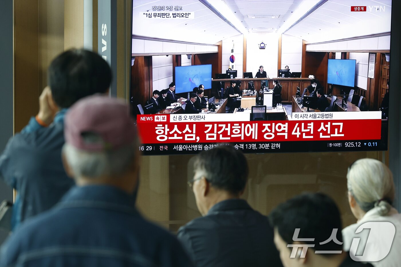 본문 이미지 - 28일 오후 서울시 용산구 한강대로 서울역 대합실에서 시민들이 자본시장과 금융투자업에 관한 법률 위반, 정치자금법 위반, 특정범죄 가중처벌 등에 관한 법률 위반(알선수재) 혐의를 받는 김건희 여사의 항소심 선고공판 생중계를 지켜보고 있다. 2026.4.28 ⓒ 뉴스1 박정호 기자