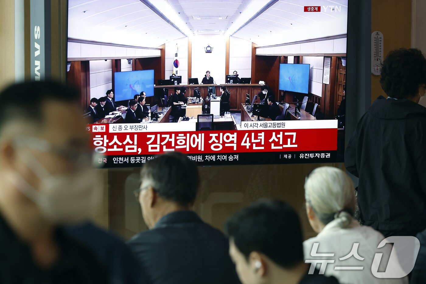 본문 이미지 - 28일 오후 서울시 용산구 한강대로 서울역 대합실에서 시민들이 자본시장과 금융투자업에 관한 법률 위반, 정치자금법 위반, 특정범죄 가중처벌 등에 관한 법률 위반(알선수재) 혐의를 받는 김건희 여사의 항소심 선고공판 생중계를 지켜보고 있다.  2026.4.28 ⓒ 뉴스1 박정호 기자