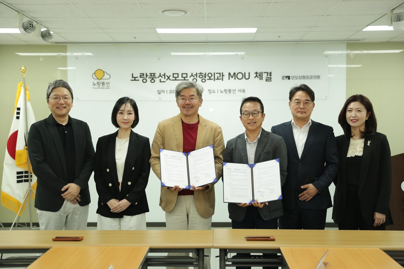 본문 이미지 - 김승준 모모성형외과 대표원장(왼쪽에서 세번째)과 김진국 노랑풍선 대표가 양사 임직원들과 함께 기념 사진을 찍고 있다.(노랑풍선 제공)