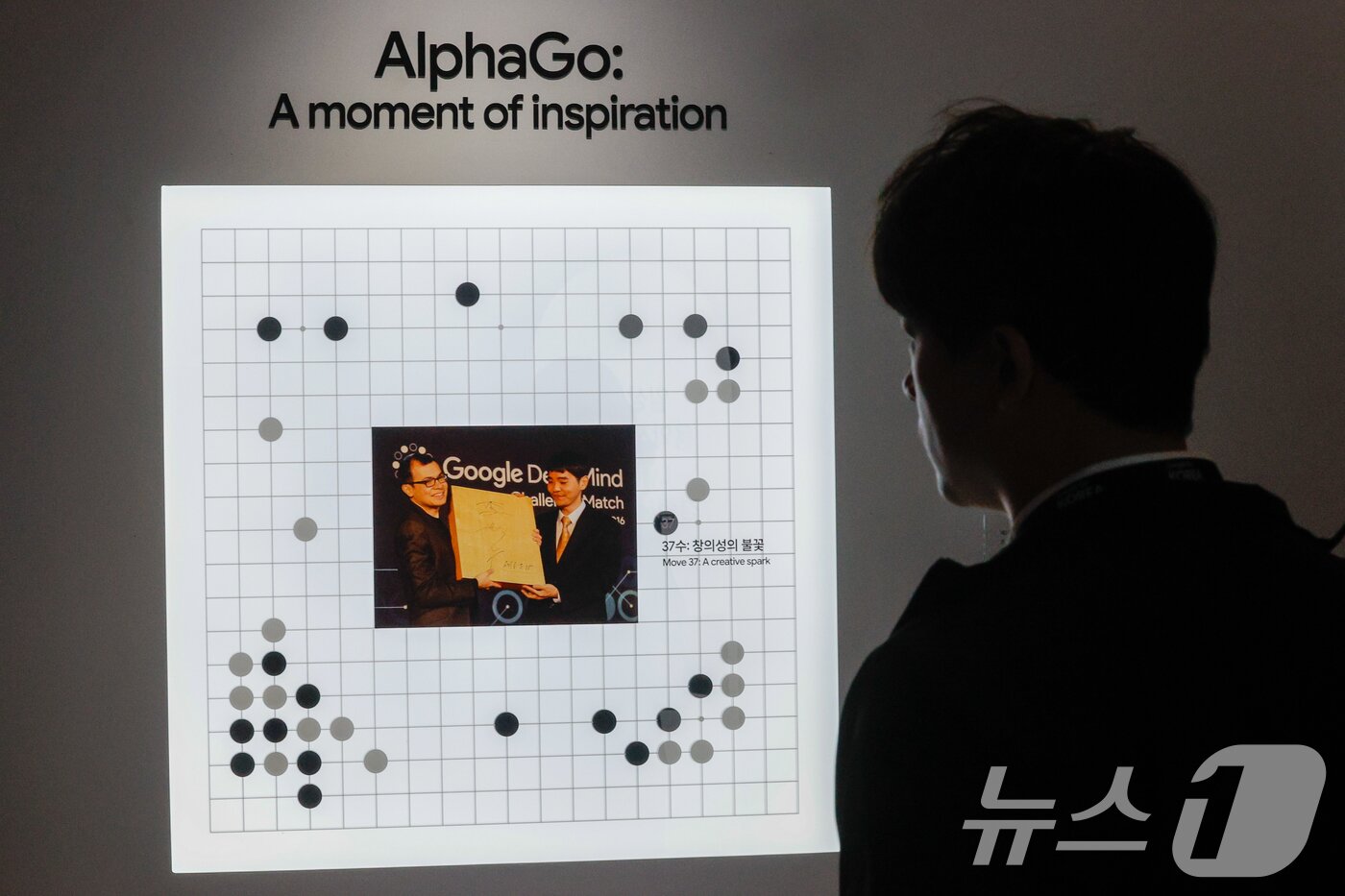 본문 이미지 - 29일 서울 중구 웨스틴조선호텔에서 열린 구글 포 코리아 위드 구글 딥마인드(Google for Korea with Google Deepmind) 행사에서 한 참석자가 2016년 이세돌 9단과 바둑 AI 알파고의 대국 당시 사진을 보고 있다. 2026.4.29 ⓒ 뉴스1 안은나 기자