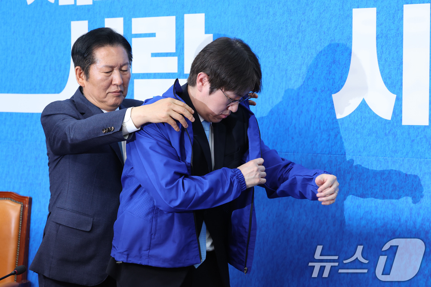 (서울=뉴스1) 신웅수 기자 = 정청래 더불어민주당 대표가 29일 서울 여의도 국회에서 열린 민주당 인재 영입식에서 하정우 전 청와대 AI수석에게 당 점퍼를 입혀주고 있다. 202 …