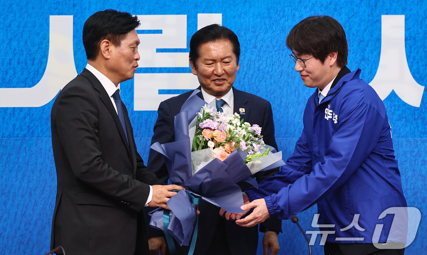 본문 이미지 - 하정우 전 청와대 AI미래기획수석이 29일 서울 여의도 국회에서 열린 더불어민주당 인재영입식에서 조승래 사무총장에게 꽃다발을 전달받고 정청래 더불어민주당 대표와 기념촬영을 하고 있다. ⓒ 뉴스1 김도우 기자