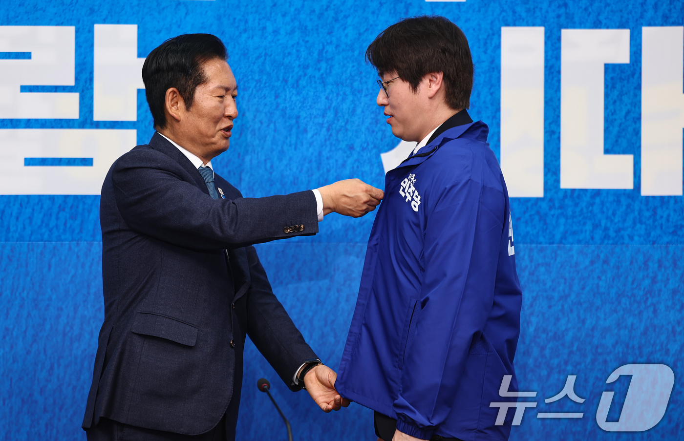 (서울=뉴스1) 김도우 기자 = 정청래 더불어민주당 대표가 29일 서울 여의도 국회에서 열린 더불어민주당 인재영입식에서 하정우 전 청와대 AI미래기획수석에게 당 점퍼를 입혀주고 있 …