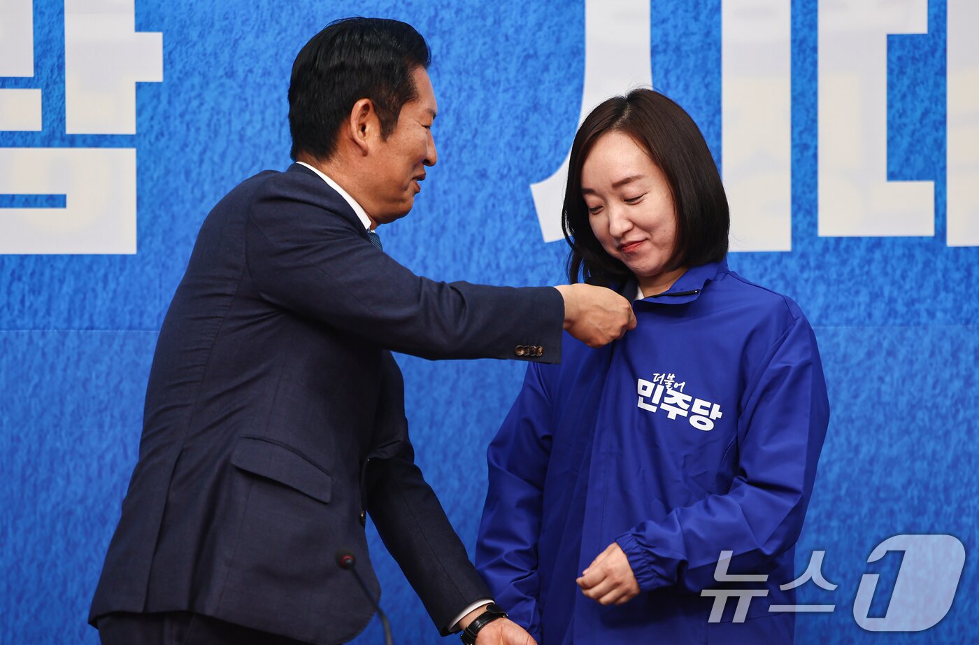 본문 이미지 - 정청래 더불어민주당 대표가 29일 서울 여의도 국회에서 열린 더불어민주당 인재영입식에서 전은수 전 청와대 대변인에게 당 점퍼를 입혀주고 있다. ⓒ 뉴스1 김도우 기자