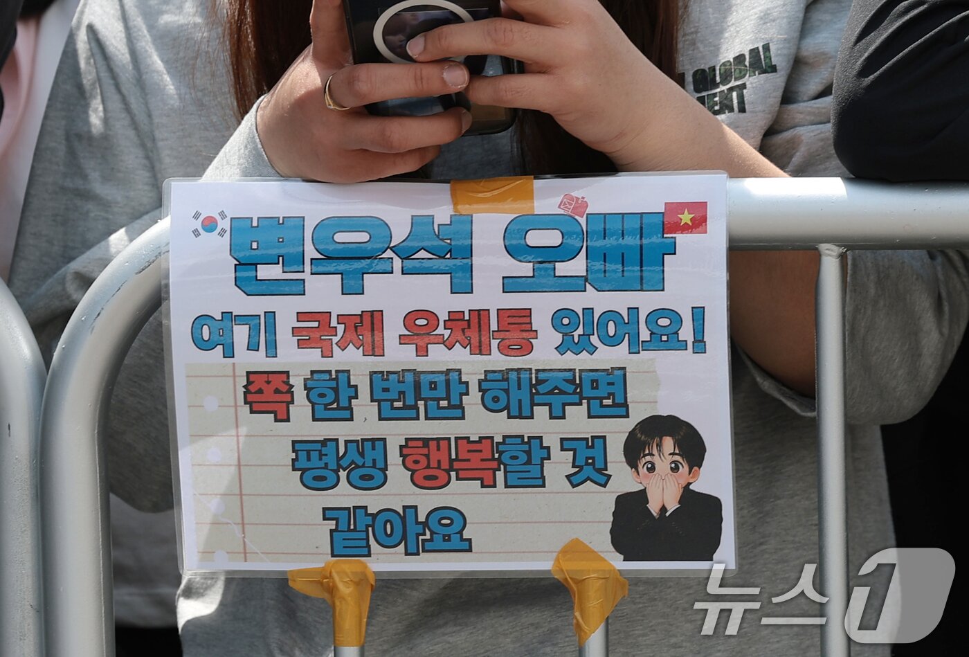 본문 이미지 - 29일 서울 성동구 쎈느 인근에서 아웃도어 브랜드 디스커버리 익스페이션의 여름 시즌 브랜드 체험 행사에 참석하는 배우 변우석을 보기위해 한 해외 팬이 변우석을 기다리고 있다. ⓒ 뉴스1 권현진 기자