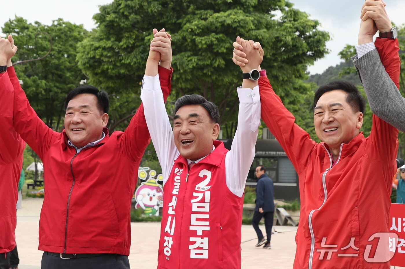 본문 이미지 - 김두겸 울산시장이 29일 울산 중구 태화강 국가정원 광장에서 출마 기자회견을 연 가운데 박성민(왼쪽), 김기현 의원과 두 손을 맞잡으며 승리를 다짐하고 있다. 2026.4.29 ⓒ 뉴스1 조민주 기자