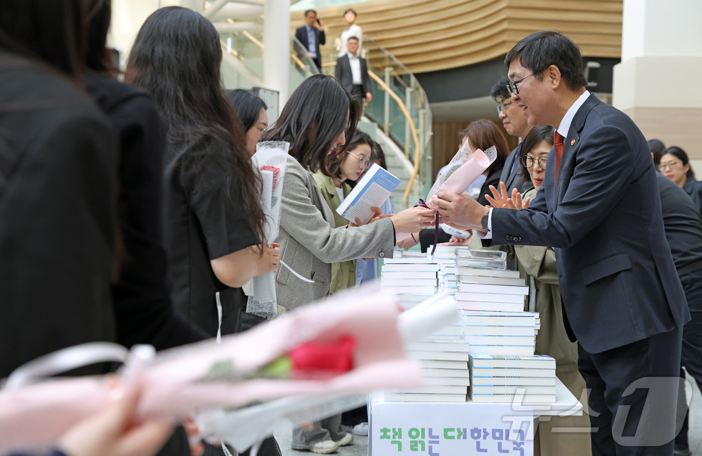 (서울=뉴스1) = 최휘영 문화체육관광부 장관이 29일 정부세종청사 15동 문체부 로비에서 세계 책의 날(4월 23일)을 기념해 직원에게 책을 선물하고 꽃을 선물 받고 있다. (문 …