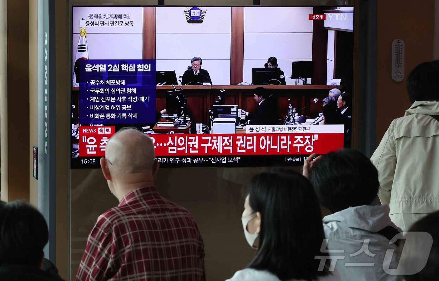 본문 이미지 - 29일 오후 서울시 용산구 한강대로 서울역 대합실에서 시민들이 특수공무집행방해, 직권남용 권리행사방해, 허위공문서 작성 등의 혐의를 받는 윤석열 전 대통령의 항소심 선고 공판 생중계를 지켜보고 있다. 2026.4.29 ⓒ 뉴스1 김진환 기자