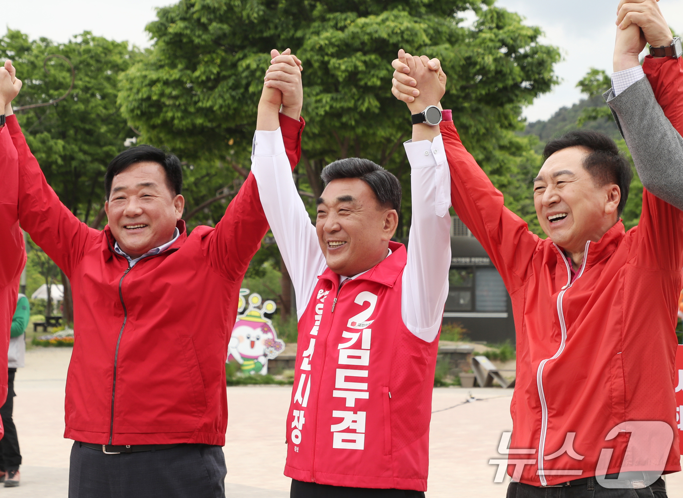 (울산=뉴스1) 조민주 기자 = 김두겸 울산시장이 29일 울산 중구 태화강 국가정원 광장에서 출마 기자회견을 연 가운데 박성민(왼쪽), 김기현 의원과 두 손을 맞잡으며 승리를 다짐 …