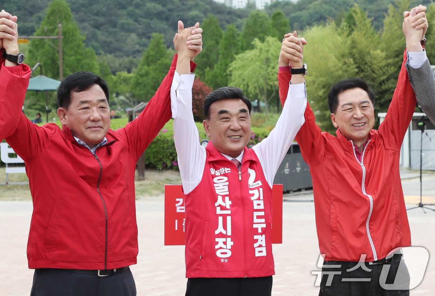 본문 이미지 - 김두겸 울산시장이 29일 울산 중구 태화강 국가정원 광장에서 출마 기자회견을 연 가운데 박성민(왼쪽), 김기현 의원과 두 손을 맞잡으며 승리를 다짐하고 있다. 2026.4.29 ⓒ 뉴스1 조민주 기자